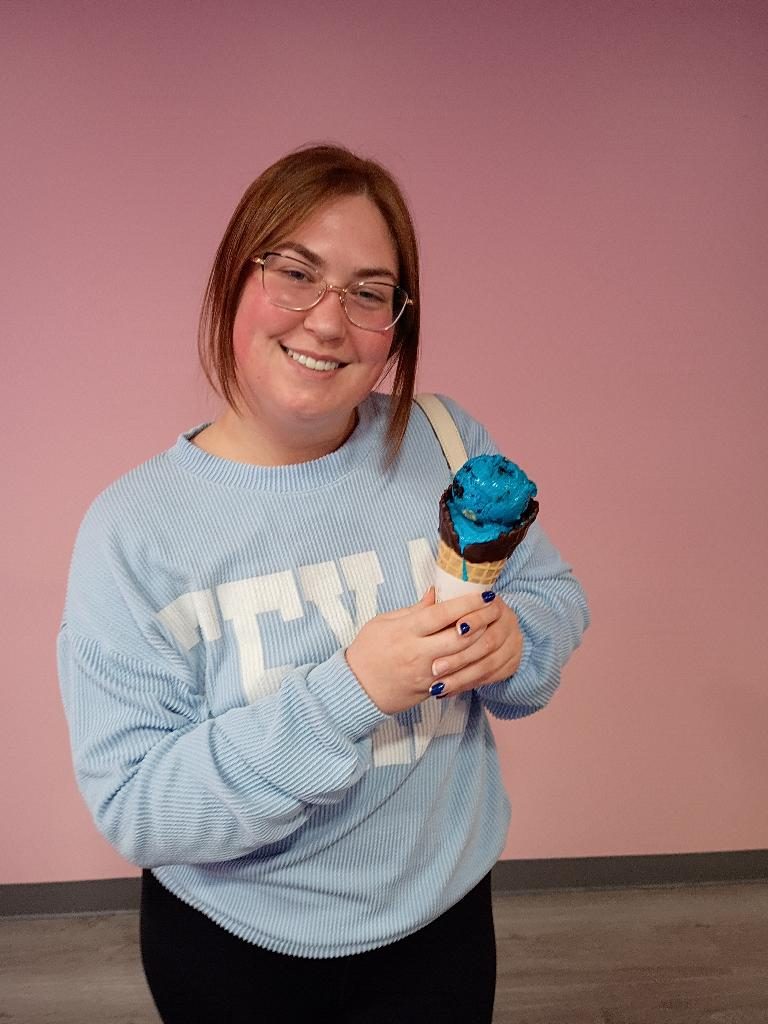 Customer holding a colorful cone at Scoops